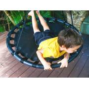 Boy lying face down across the 100cm black nest swing on a deck