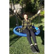 Woman sitting on the heavy duty nest swing holding the ropes