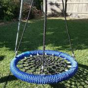 Heavy duty blue rope nest swing hung from a tripod stand, close view