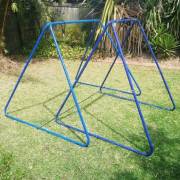 Medium and large swing set stands side by side on a lawn